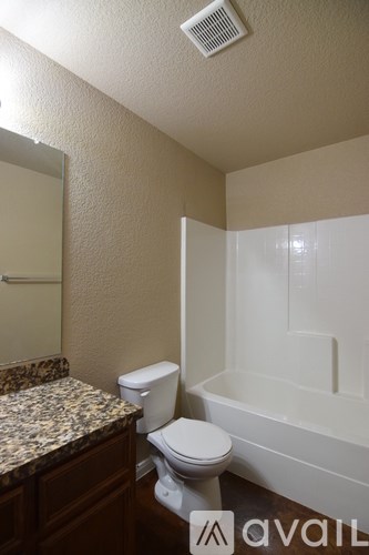 A bathroom with a toilet, sink, and bathtub.