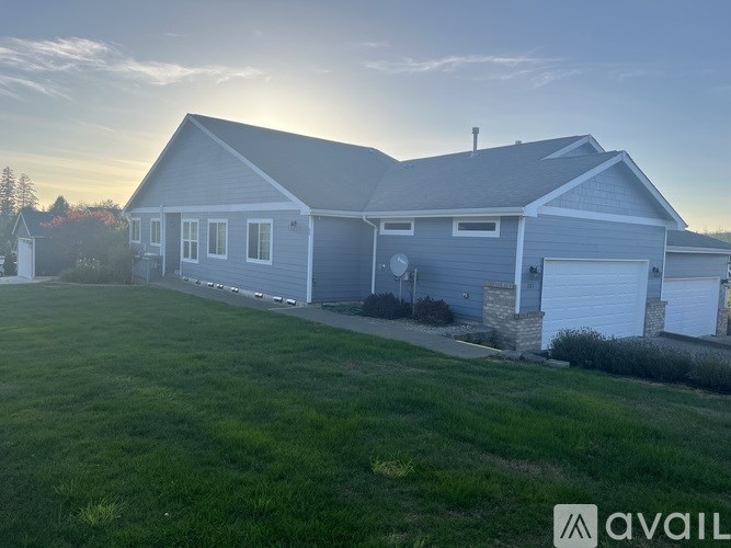 A house with a grey roof and a white garage door is available for sale.