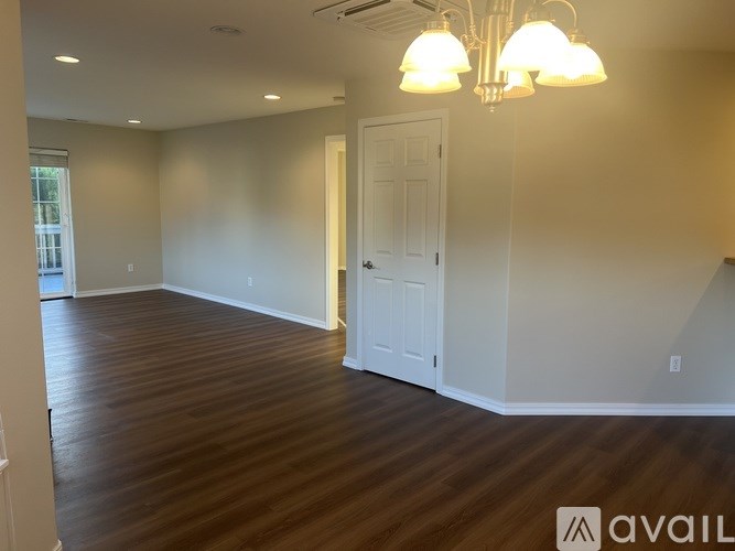 A room with wooden floors and a white door.