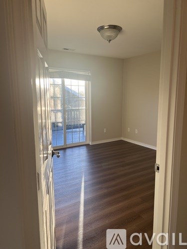 A room with wooden floors and a window with blinds.