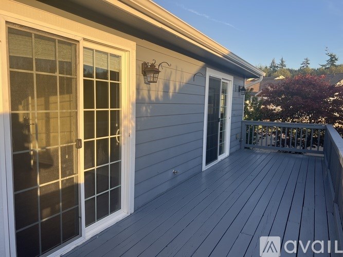 A deck with a sliding glass door and a lantern hanging on the wall.