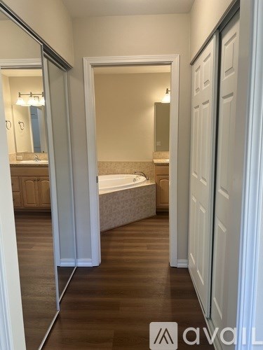 A bathroom with a tub and a mirror.
