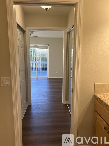 A hallway with a wooden floor and white walls.
