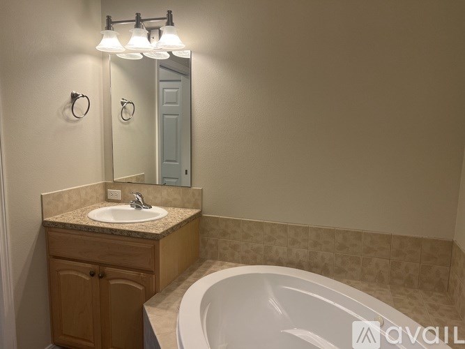 A bathroom with a white sink and a white bathtub.