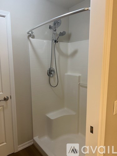 A white bathroom with a shower and a door.