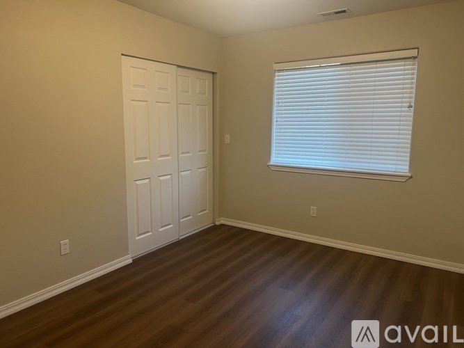 A room with a white door and a window with blinds.