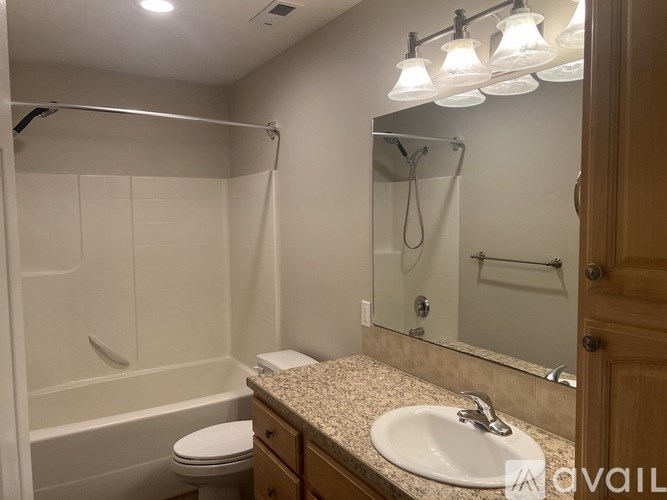 A bathroom with a sink, toilet, and a shower with a glass door.