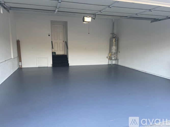 A spacious room with a door and a staircase.