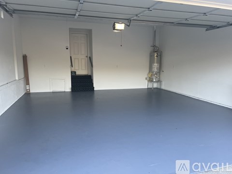 A spacious room with a door and a staircase.