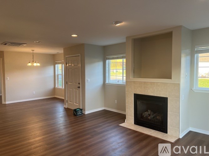 A room with a fireplace and a wooden floor.