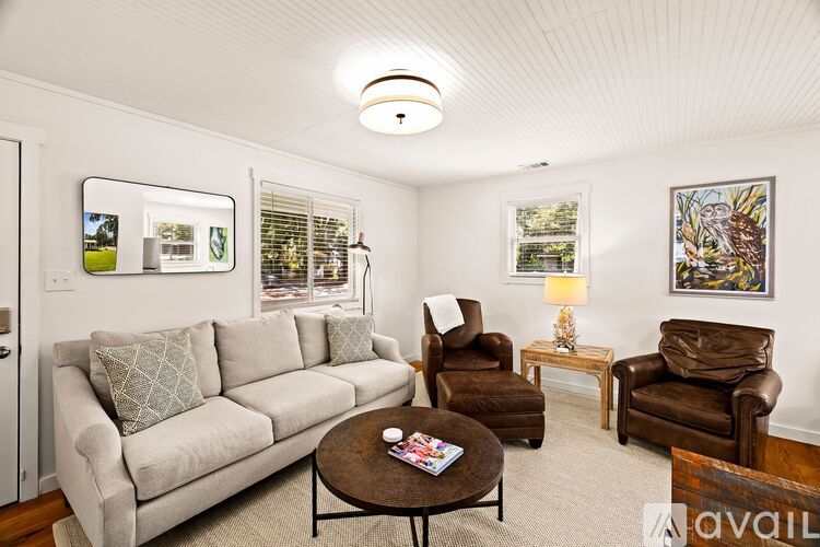 A living room with a couch, chairs, and a coffee table.