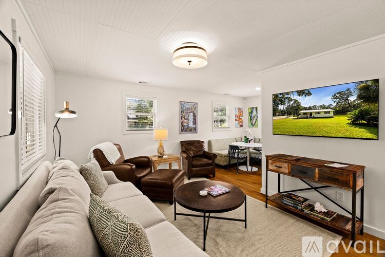 A living room with a couch, chairs, and a coffee table.