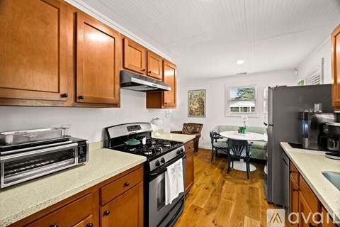 A kitchen with wooden cabinets and a black stove top.