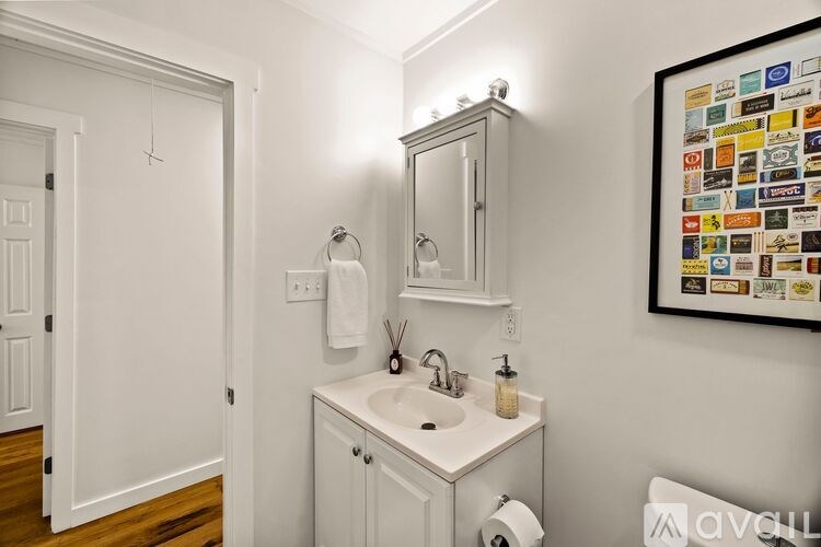 A white bathroom with a sink and a mirror.