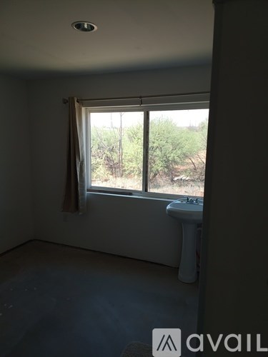 A bathroom with a window overlooking a natural landscape.
