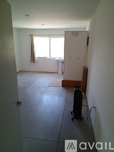 A room with a window and a suitcase on the floor.