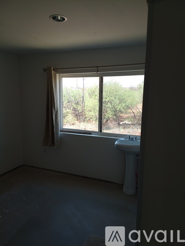 A bathroom with a window overlooking a natural landscape.