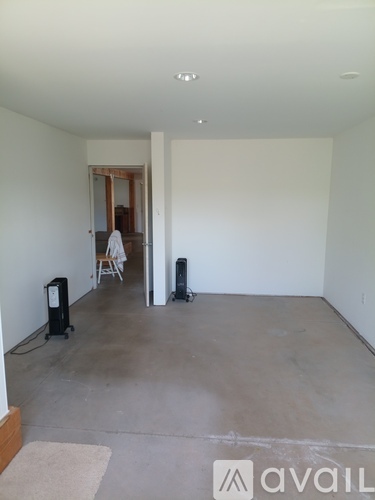 A room with a white wall and a carpet on the floor.
