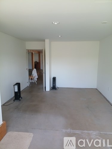 A room with a white wall and a carpet on the floor.