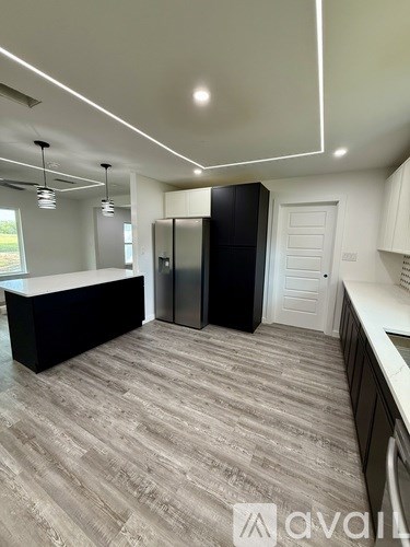 A kitchen with a black counter and grey flooring.