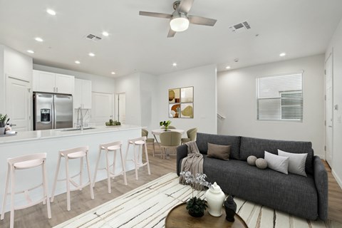 A modern living room with a grey couch and a bar area.