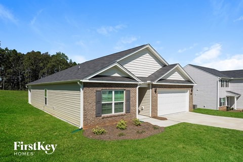 A house with a garage and a driveway is for sale by FirstKey Homes.