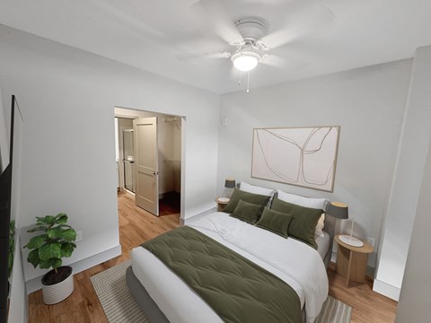 A bedroom with a bed, a ceiling fan, and a potted plant.