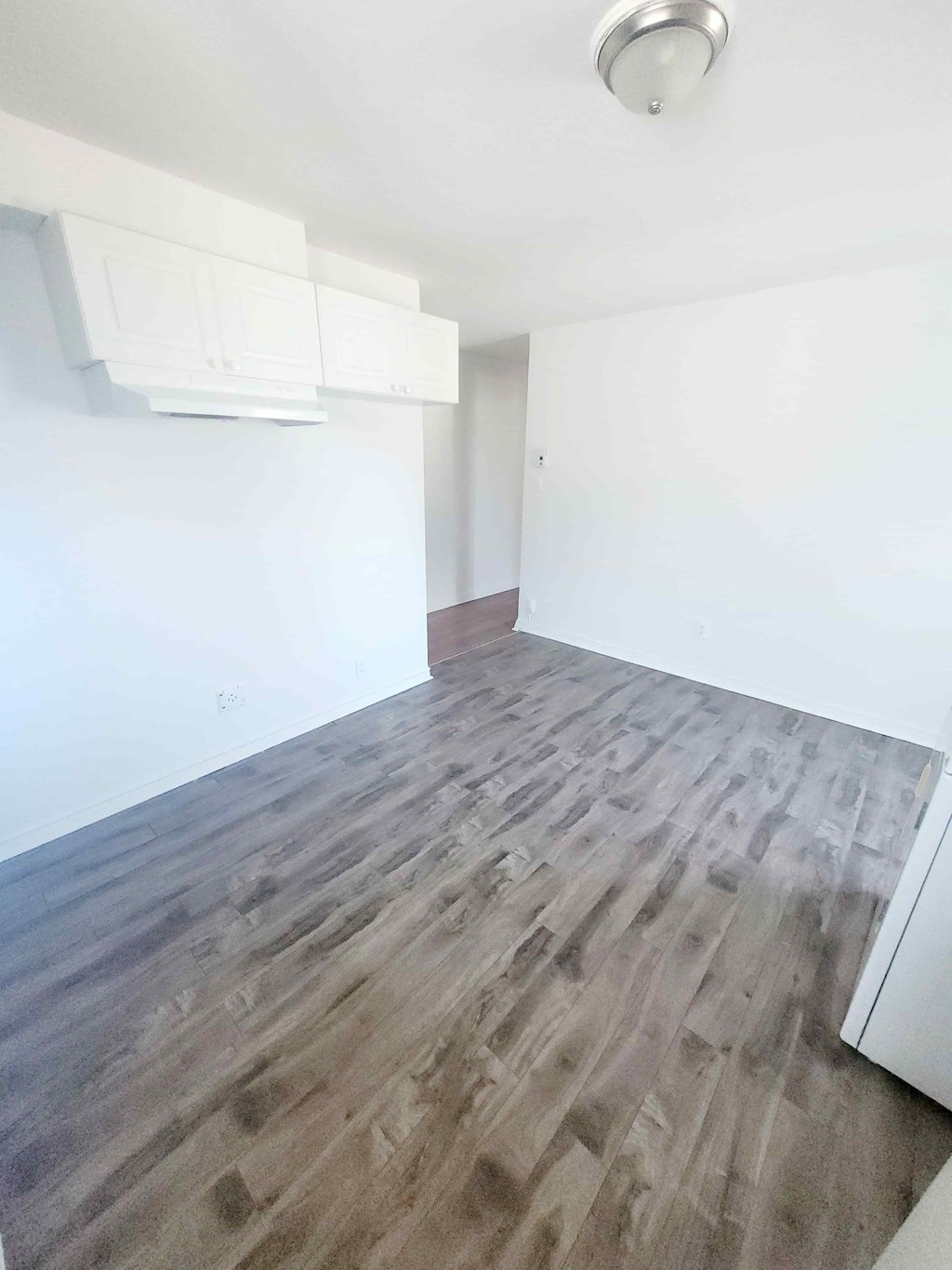 A room with a wooden floor and a window.