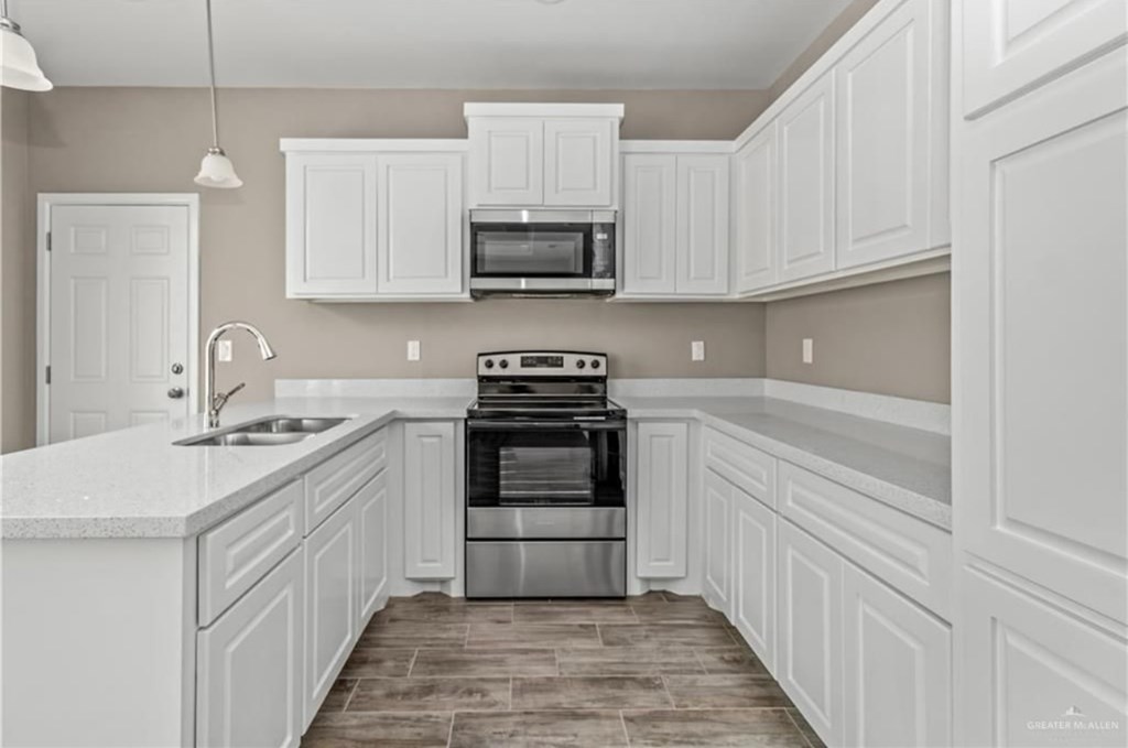 A kitchen with white cabinets and a stainless steel oven.