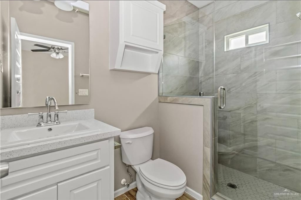 A bathroom with a toilet, sink, and shower.