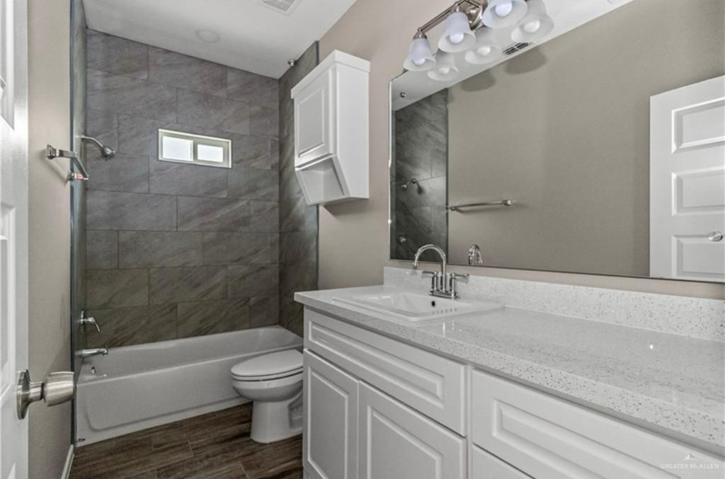 A bathroom with a white sink and a white toilet.