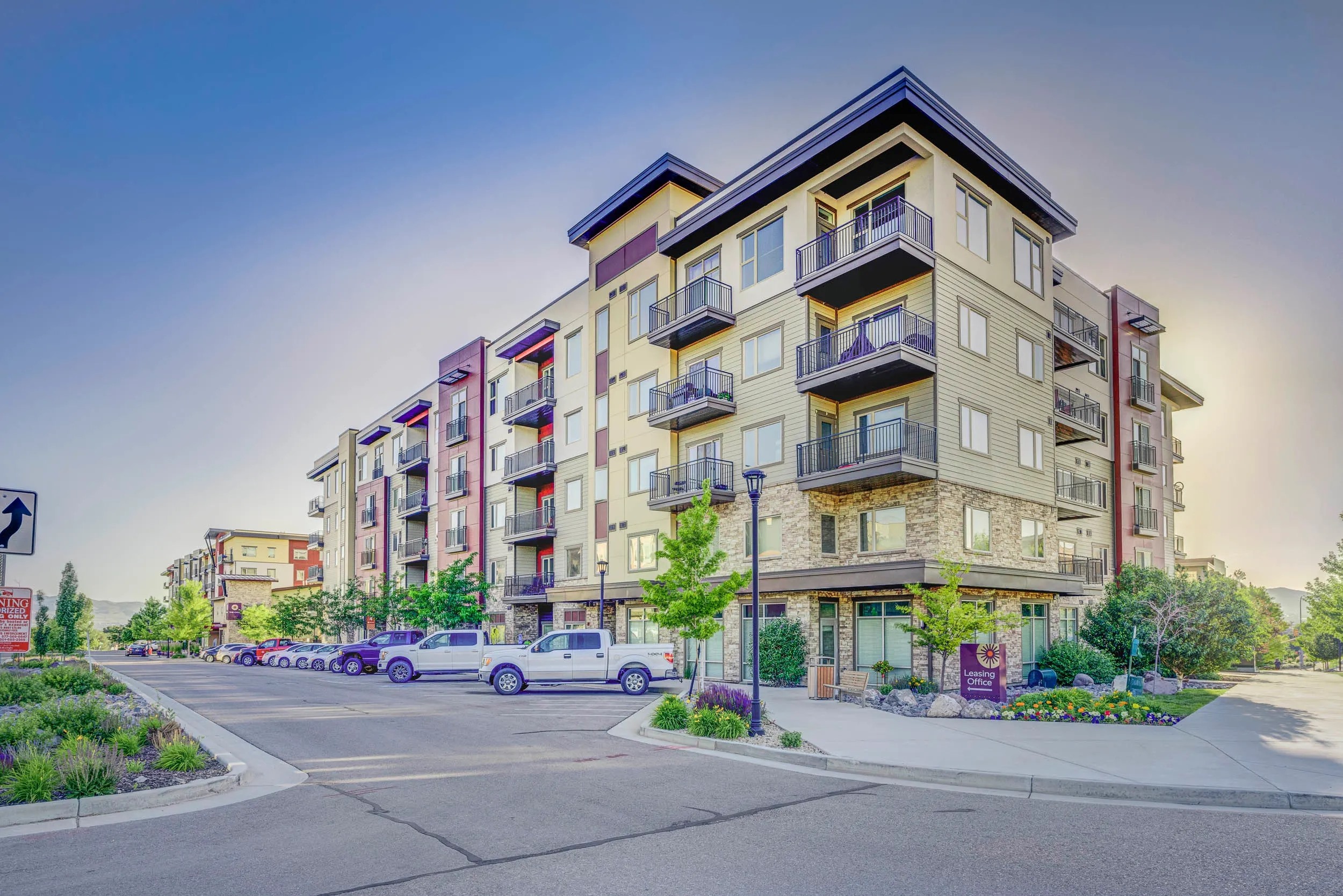 Apartment building with cars parked in front.