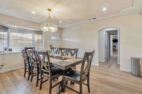 A dining room with a table and chairs.