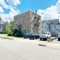 A street with cars and buildings on both sides.