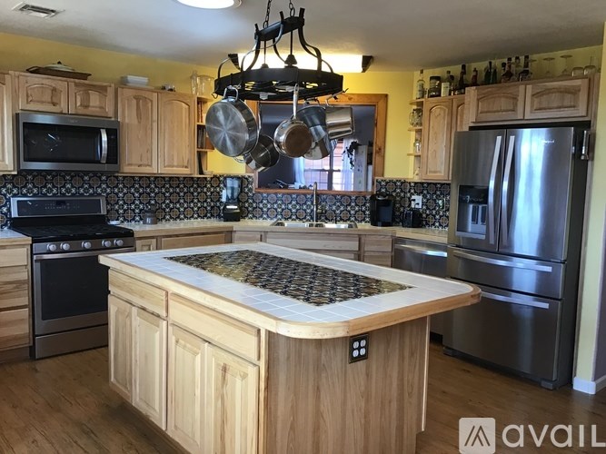 A kitchen with wooden cabinets and a black and white tiled backsplash.