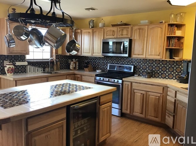 A kitchen with wooden cabinets and a black and white tiled backsplash.