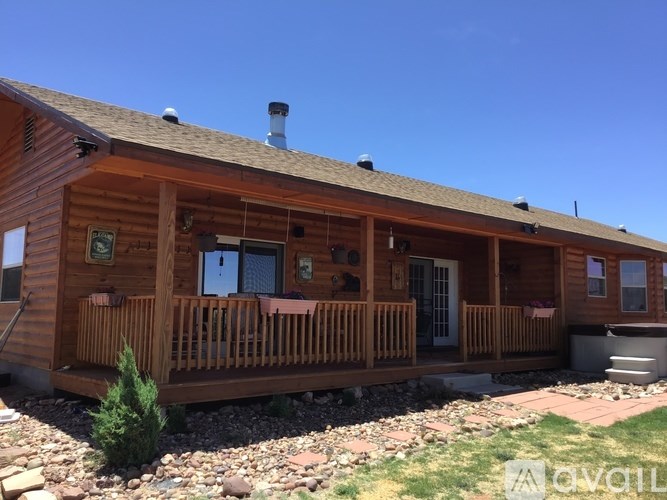 A wooden cabin with a porch and a hot tub.