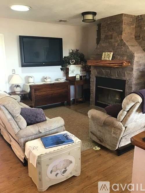 A living room with a fireplace and a television mounted on the wall.