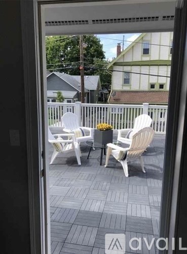 A patio with white chairs and a table is visible through a glass door.