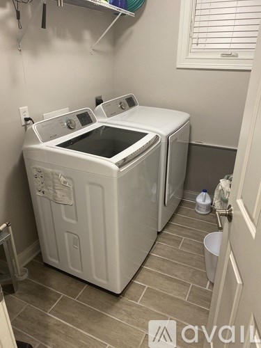 A small laundry room with a washer and dryer.