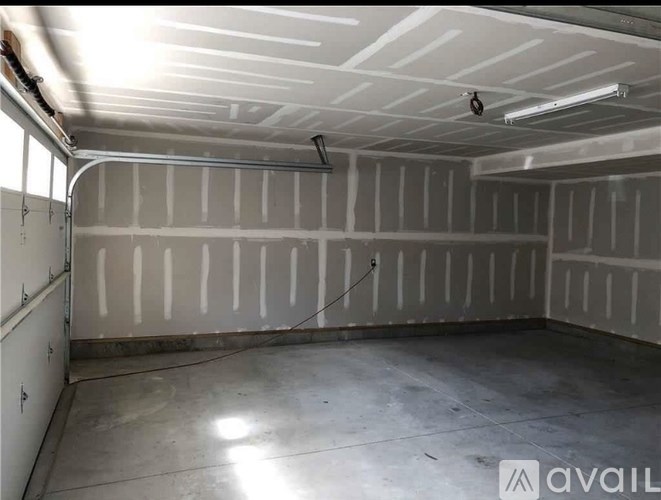 A spacious garage with a concrete floor and walls covered in insulation.