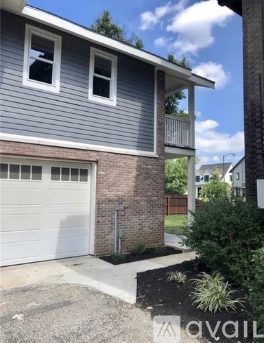 A house with a grey siding and a white garage door.
