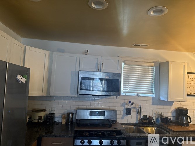 A kitchen with a stove, microwave, and refrigerator.