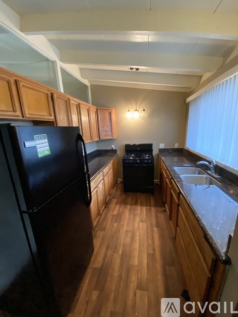 A kitchen with wooden cabinets and black appliances.