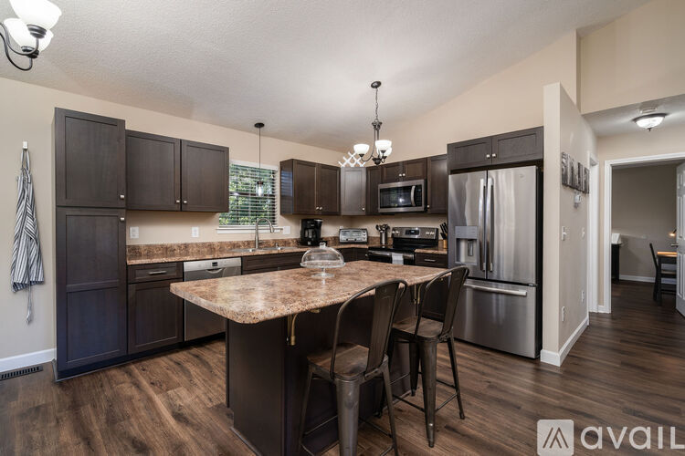A kitchen with dark wood cabinets and a granite countertop.