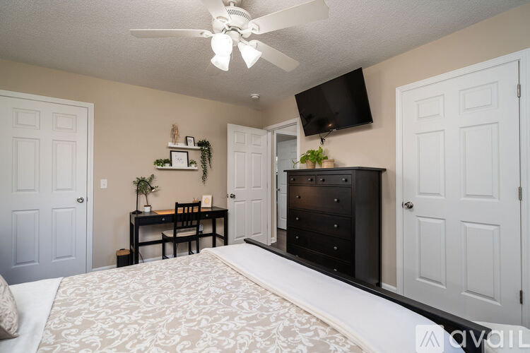 A bedroom with a large bed and a ceiling fan.