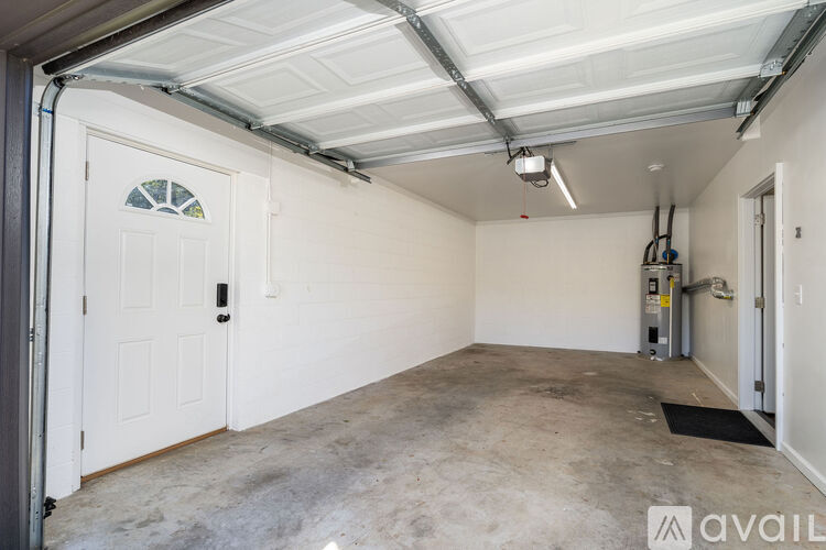 A spacious garage with a white door and a concrete floor.