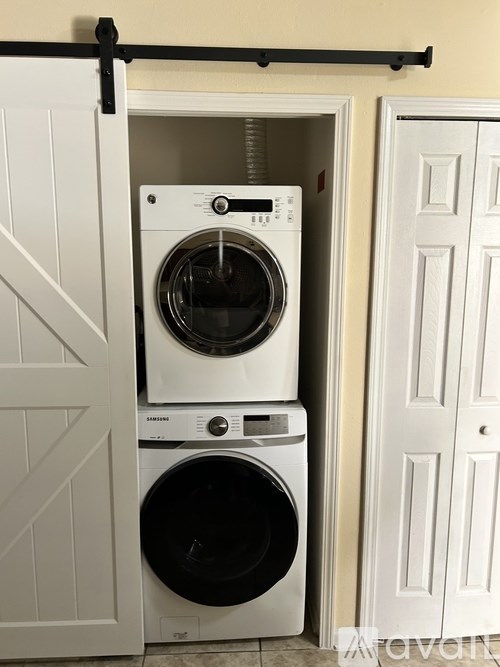 A white washing machine and dryer in a small laundry room.