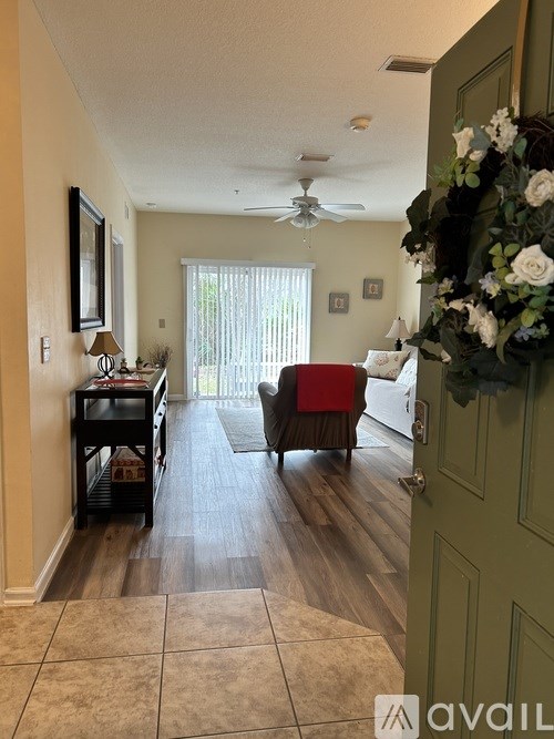 A living room with a red couch and a green door.