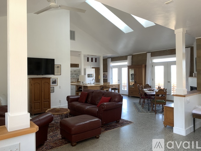 A living room with a brown leather sofa and a television.